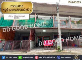 Front view of a residential building with visible signboards and green covers on the upper floor balcony.