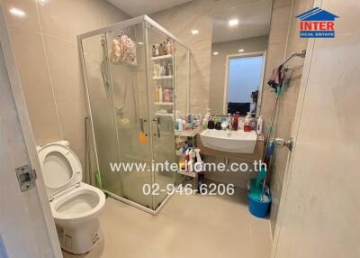 Modern bathroom with glass shower, toilet, and sink with mirror