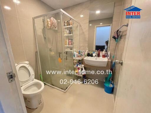 Modern bathroom with glass shower, toilet, and sink with mirror