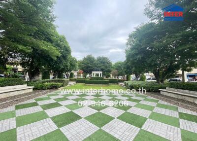 Beautifully landscaped garden area with trees, a checker patterned walkway, and a gazebo