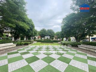 Beautifully landscaped garden area with trees, a checker patterned walkway, and a gazebo