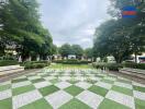 Beautifully landscaped garden area with trees, a checker patterned walkway, and a gazebo