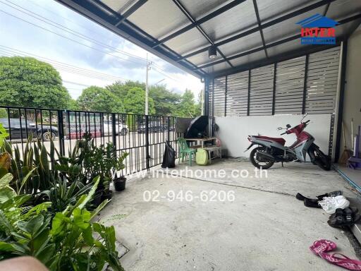 Covered outdoor area with potted plants and a motorbike