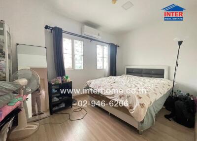 Spacious bedroom with a double bed, window, and air conditioner