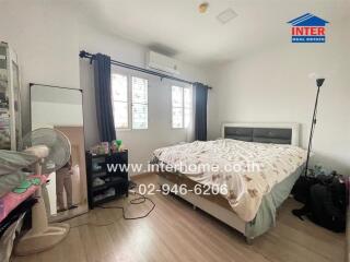 Spacious bedroom with a double bed, window, and air conditioner