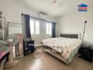 Spacious bedroom with a double bed, window, and air conditioner