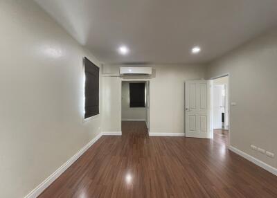 Spacious living room with wooden flooring and air conditioning