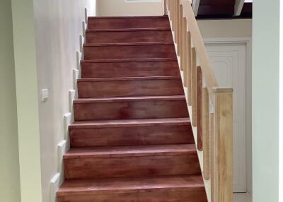 Interior view of a staircase with wooden steps and railing