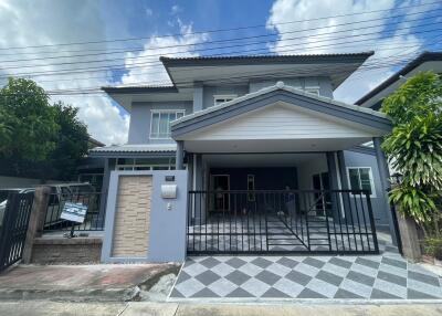 Front view of a modern two-story house with a gate and driveway