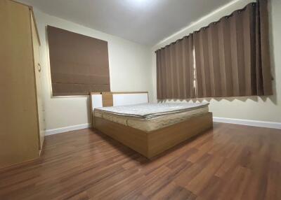 Spacious bedroom with wooden floor and bed