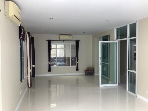 Bright and spacious living room with large windows and glass doors