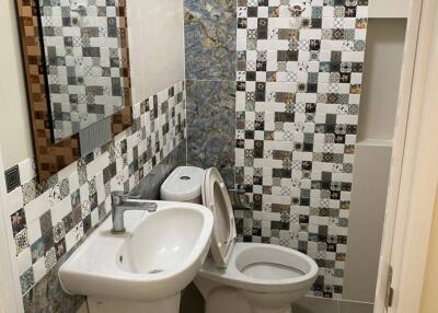 Small bathroom with unique mosaic tiles and white fixtures