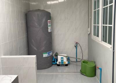 A utility room with a water tank and plumbing equipment