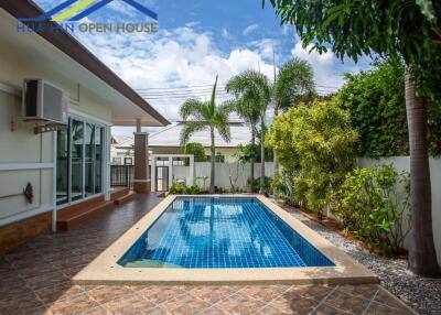 Outdoor swimming pool area with trees and plants