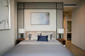 Modern bedroom with double bed, bedside tables, and wall art