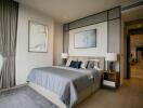 Modern stylish bedroom with large bed, side tables, art decor, and a view of a hallway.