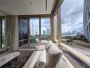 Spacious living room with large windows and city view