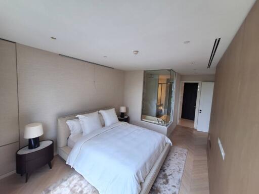 Spacious modern bedroom with an en-suite glass-walled bathroom