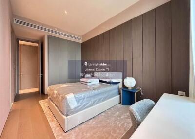 Modern bedroom with bed, bedside table, lamp, and desk