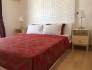 Modern bedroom with red bedding and brick accent wall