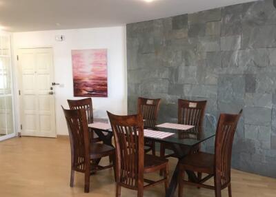 Dining room with wooden dining table and chairs, artwork and stone accent wall