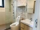 Modern bathroom with glass shower and herringbone tile accent wall