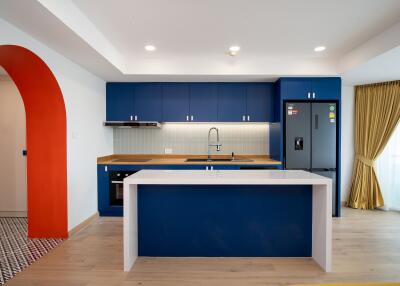 Modern kitchen with blue cabinets, island, and stainless steel appliances