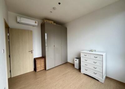 Spacious bedroom with wooden flooring, wardrobe, and chest of drawers