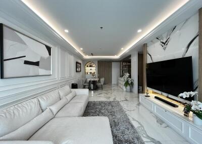 Luxurious modern living room with white sofa, marble flooring, and large TV