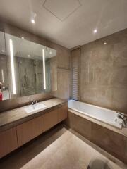 Modern bathroom with sink, bathtub, and large mirror