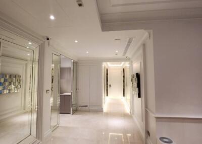 Modern hallway with white walls and ceiling, recessed lighting, mirrored walls, and wooden flooring