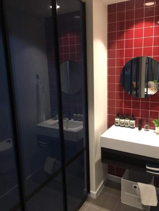 Modern bathroom with red tile accent wall