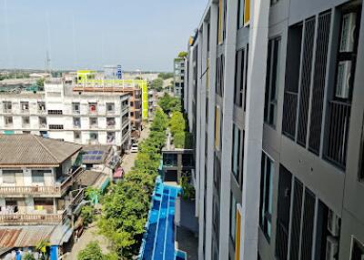 View of residential building from a higher floor with a swimming pool and surrounding structures