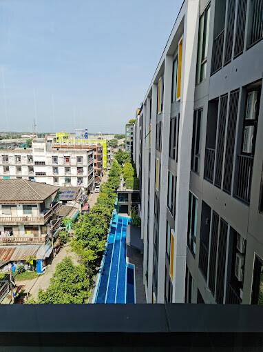 View of residential building from a higher floor with a swimming pool and surrounding structures