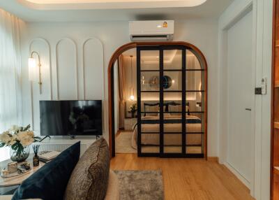 Living room with view of bedroom through glass doors