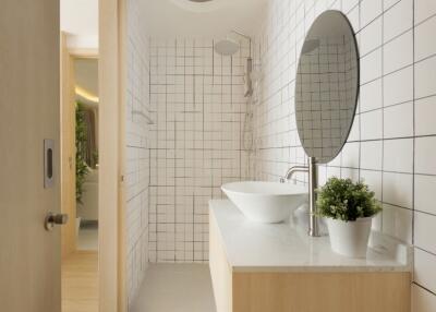 Modern bathroom with white tiles and large round mirror