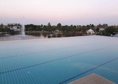 Outdoor pool area with a fountain and landscaped surroundings