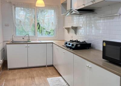 A bright and modern kitchen with white cabinetry and wooden countertops