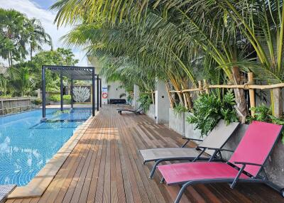 Outdoor pool area with lounge chairs and greenery