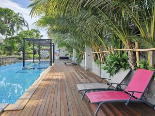 Outdoor pool area with lounge chairs and greenery