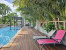 Outdoor pool area with lounge chairs and greenery