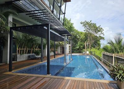 Luxurious swimming pool with deck and greenery