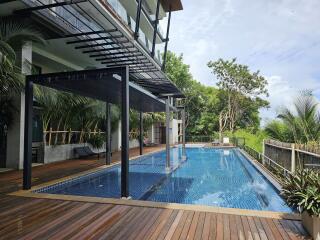 Luxurious swimming pool with deck and greenery