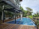 Luxurious swimming pool with deck and greenery