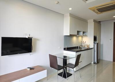 Modern kitchen and dining area with wall-mounted TV