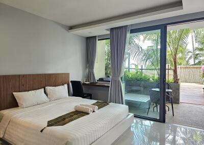 Modern bedroom with large window and view of outdoor patio