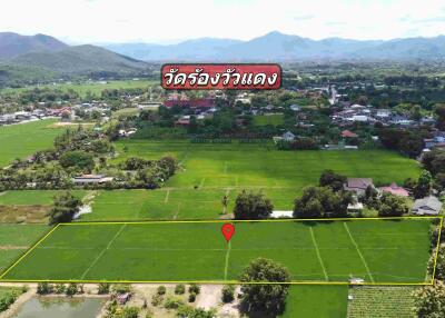 Aerial view of agricultural land with village, mountains, and labeled landmarks