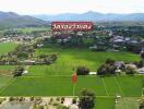 Aerial view of agricultural land with village, mountains, and labeled landmarks