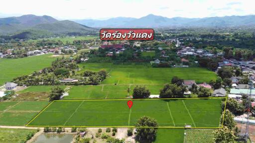 Aerial view of agricultural land with village, mountains, and labeled landmarks