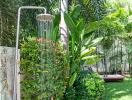 Outdoor shower surrounded by lush greenery